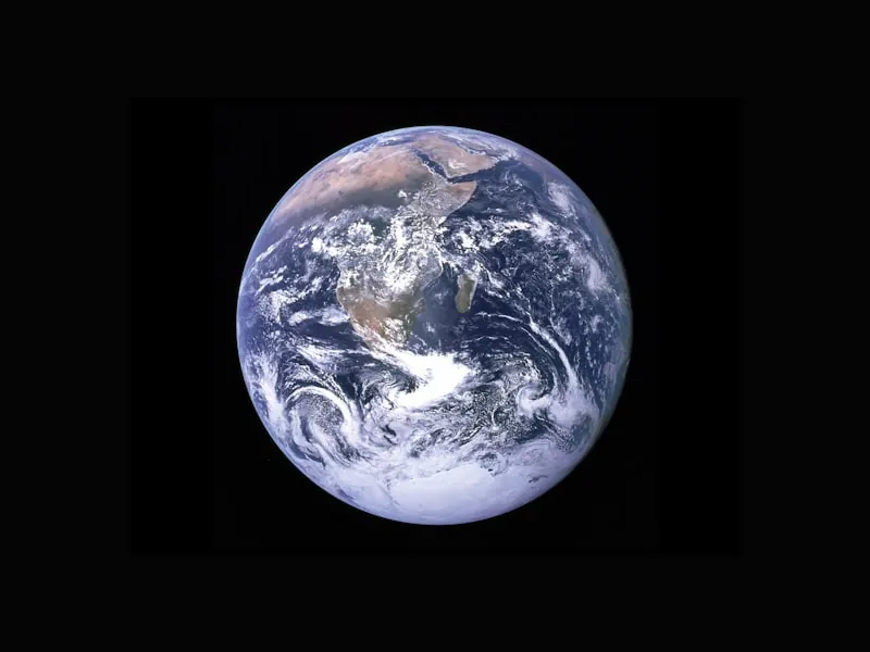 Earth, our home — a blue-and-green planet, slowly rotating, surrounded by a soft atmosphere.